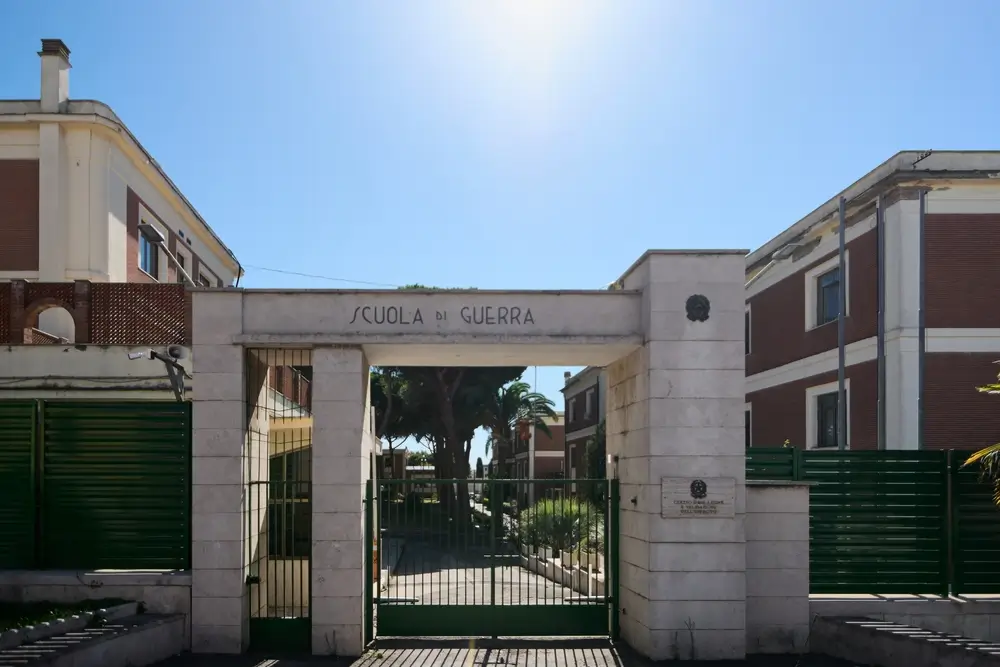 Ingresso della caserma e scuola allievi per la formazione militare con cancello e padiglioni sullo sfondo.