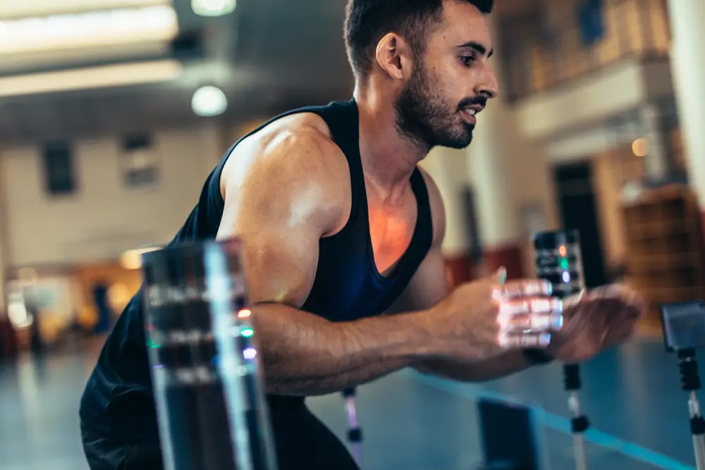 Uomo impegnato in una corsa atletica durante un test di efficienza fisica con sensori elettronici.