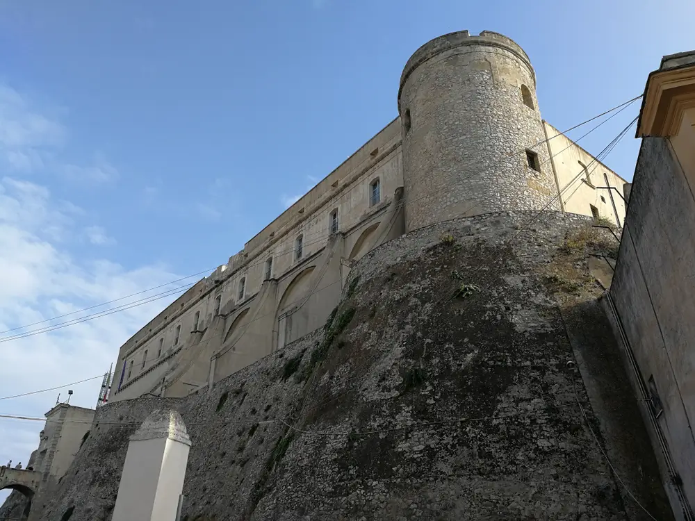 Mura fortificate e torre cilindrica in pietra della Scuola Alpina della Guardia di Finanza a Predazzo.