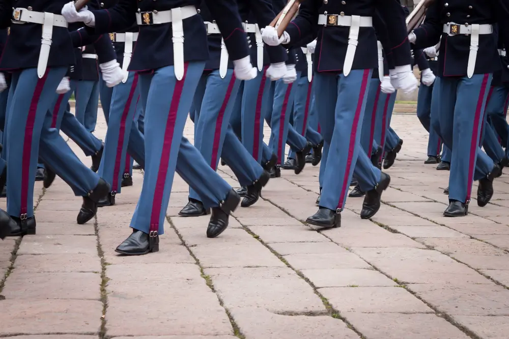 Allievi marescialli della Guardia di Finanza marciano in uniforme durante un addestramento formale.