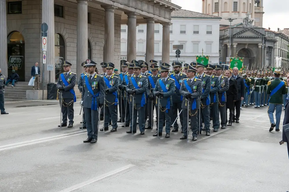 Schieramento di finanzieri della Guardia di Finanza in uniforme da cerimonia con medaglie durante un evento ufficiale.