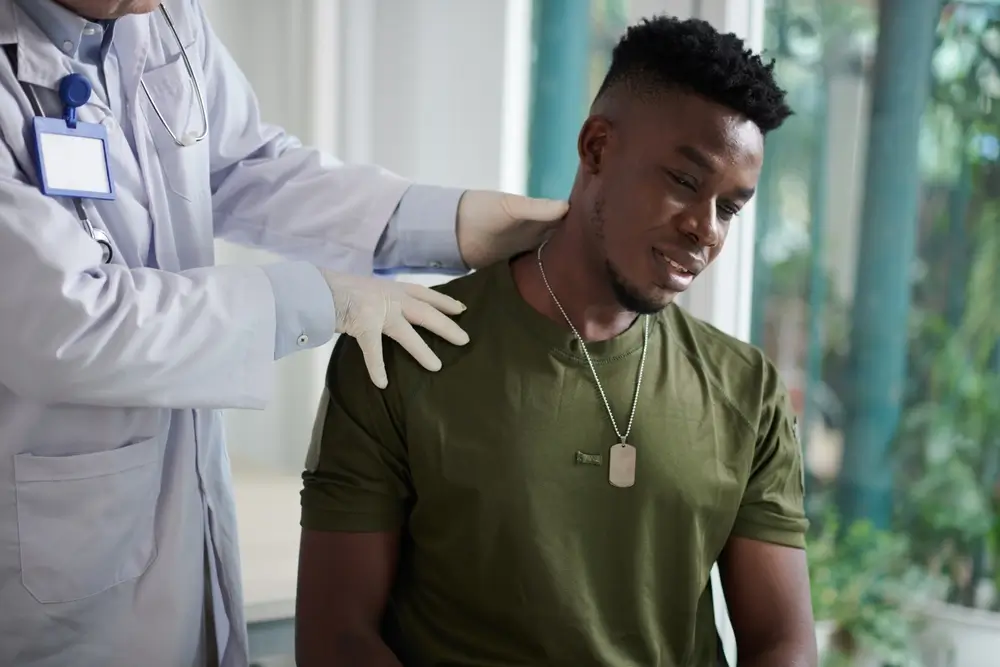 Medico esamina un giovane candidato in maglia militare durante una visita medica di selezione per un concorso.