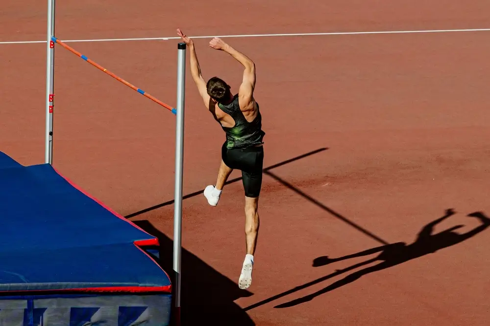 Atleta impegnato nel salto in alto durante una competizione per la selezione atletica su pista.