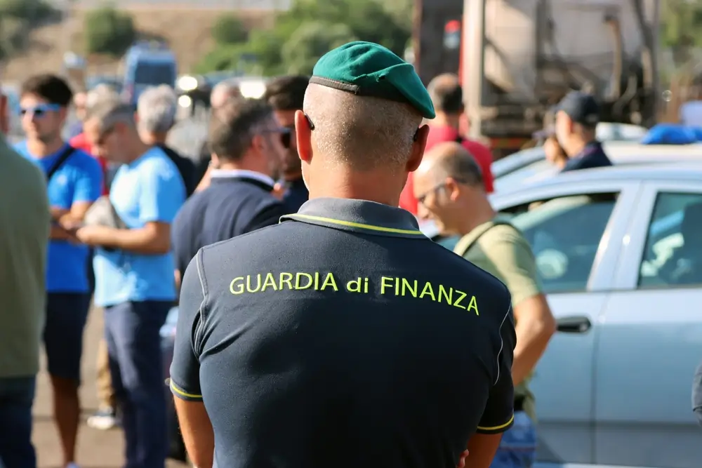 Militare della Guardia di Finanza in pattuglia, visto di spalle con polo d'ordinanza e basco verde.