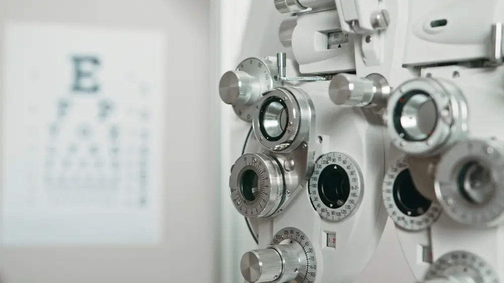 Forottero professionale e tabella ottometrica per il test della vista durante una visita oculistica di controllo.