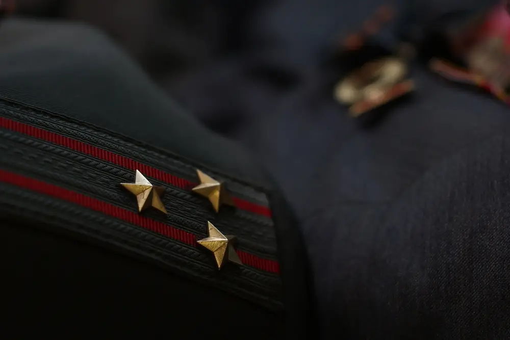 Dettaglio dei gradi con stelle dorate sulla spallina della divisa ufficiale della Guardia di Finanza.