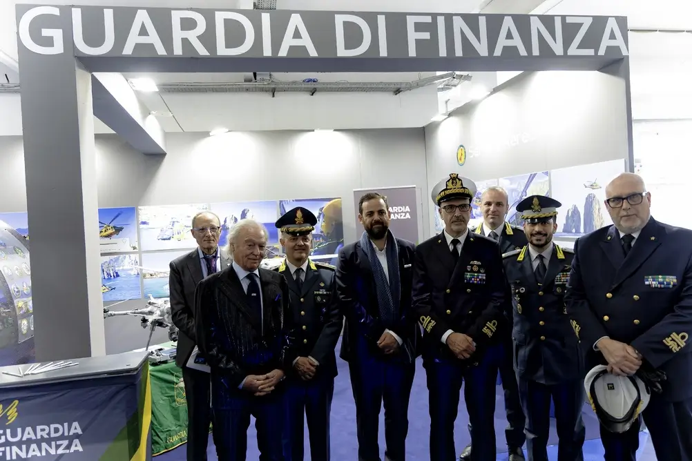 Ufficiali della Guardia di Finanza in divisa con fregi e distintivi di grado durante un evento istituzionale.