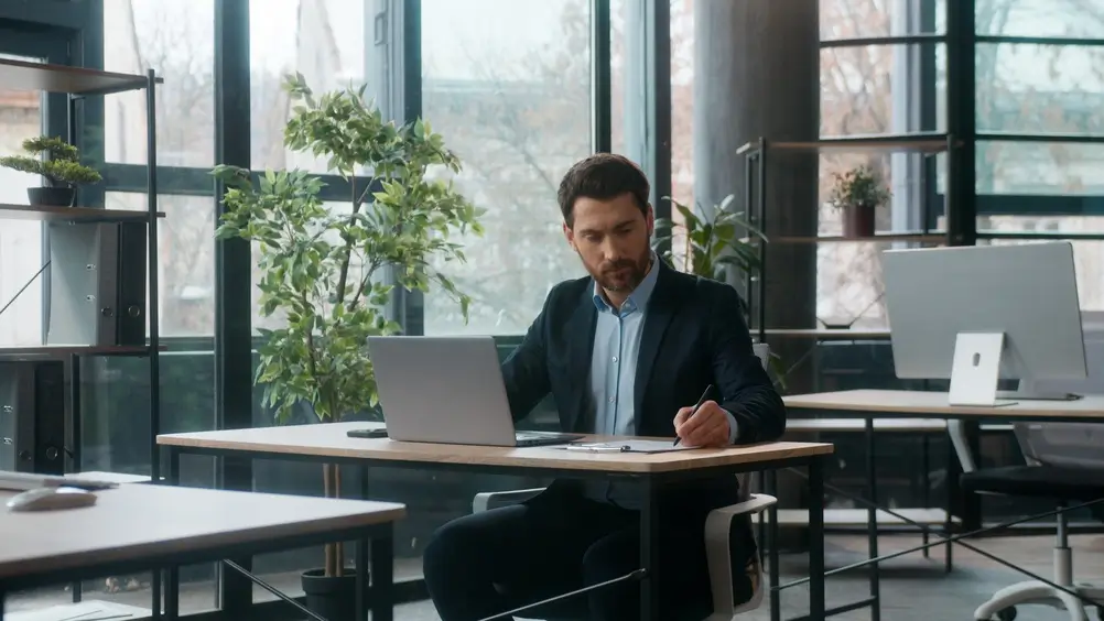 Un poliziotto della Guardia di Finanza italian in ufficio che scrive davanti al laptop per il concorso pubblico.