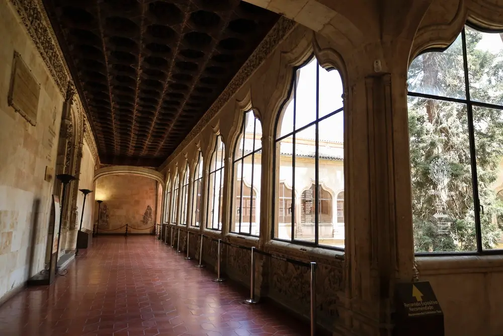 Corridoio storico con grandi vetrate e soffitto a cassettoni nella scuola allievi per la formazione militare.